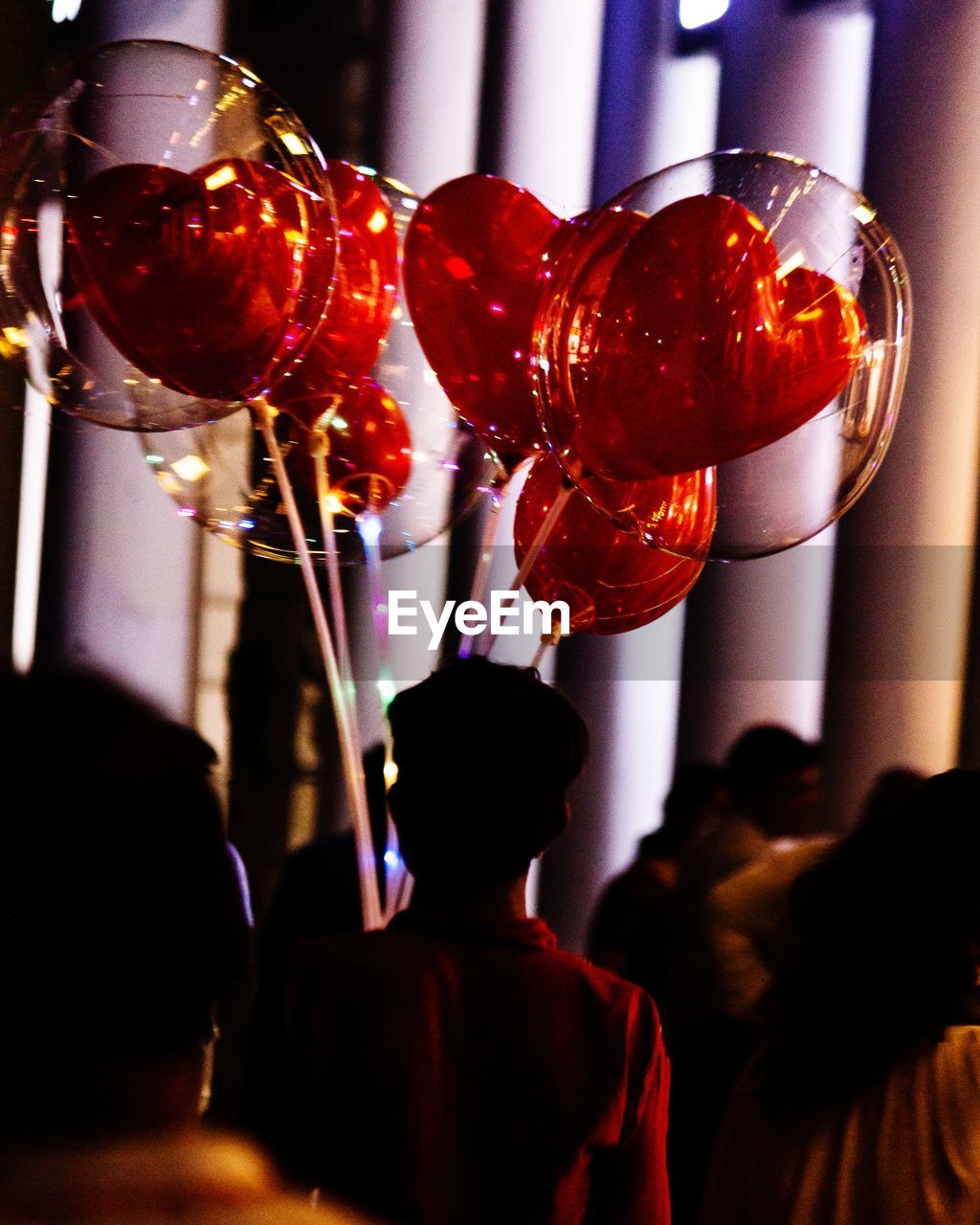 Rear view of man selling balloons 