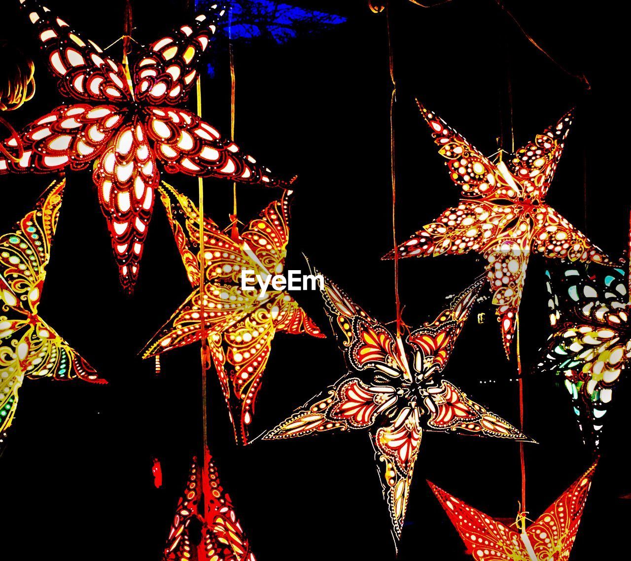 LOW ANGLE VIEW OF ILLUMINATED CHRISTMAS DECORATIONS AT NIGHT