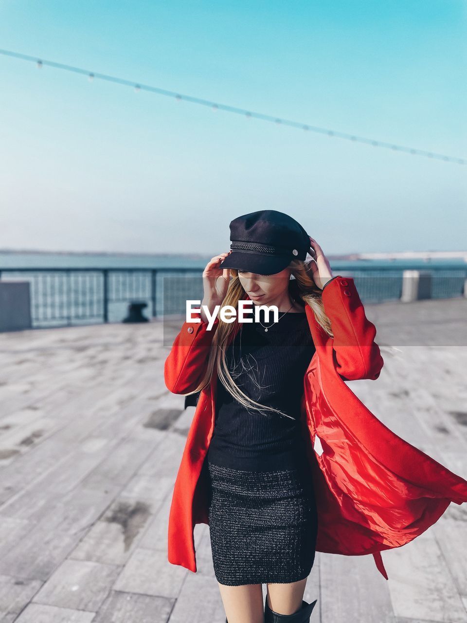 Young woman standing on river against sky