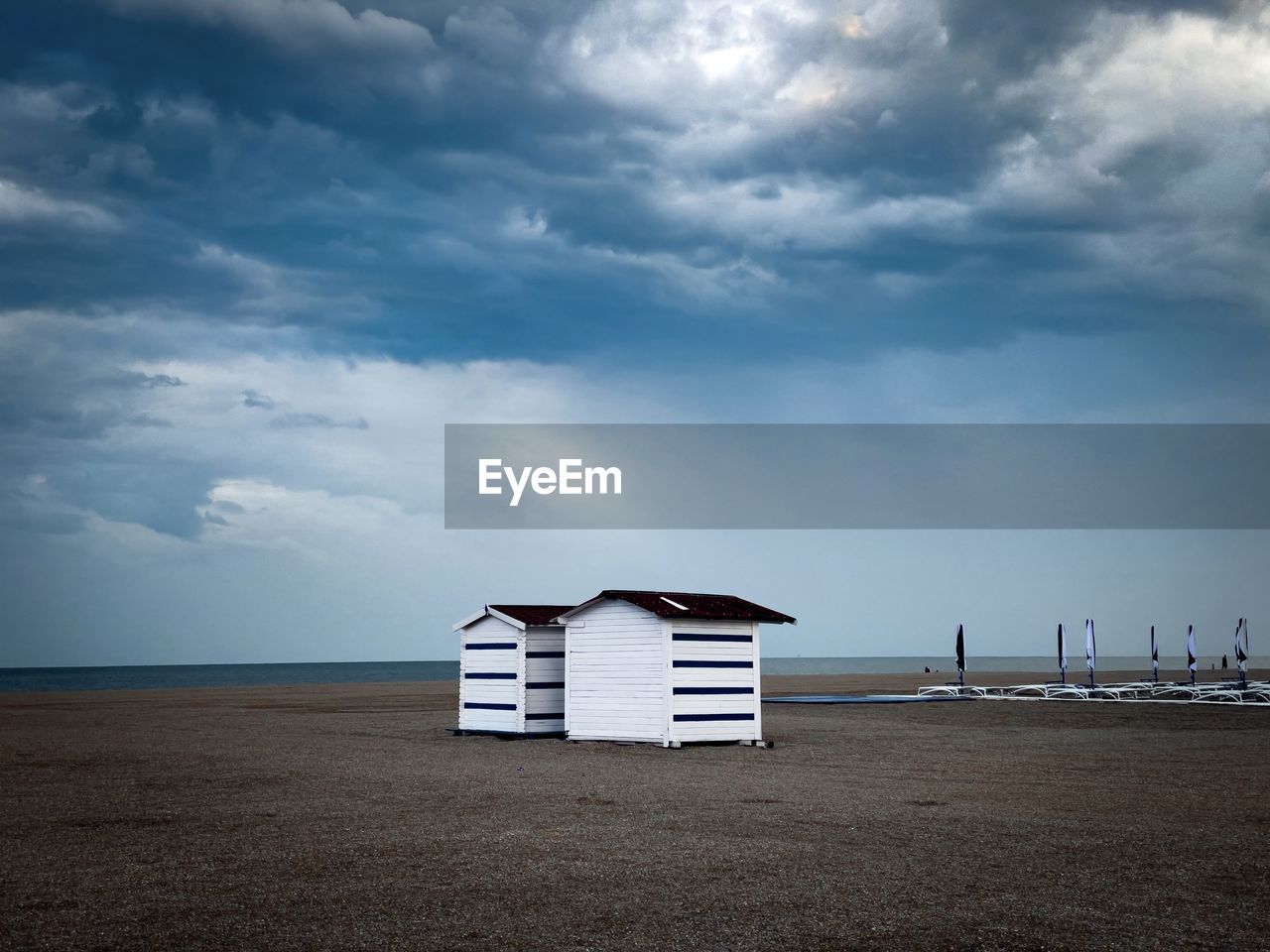 Storm clouds over two wooden houses on the beach