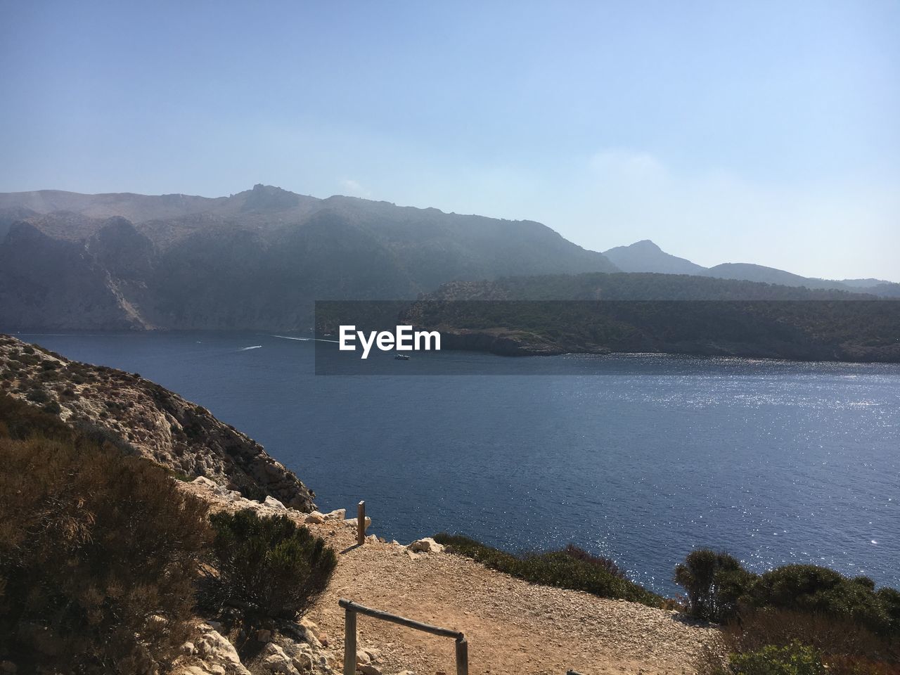 Scenic view of sea and mountains against sky