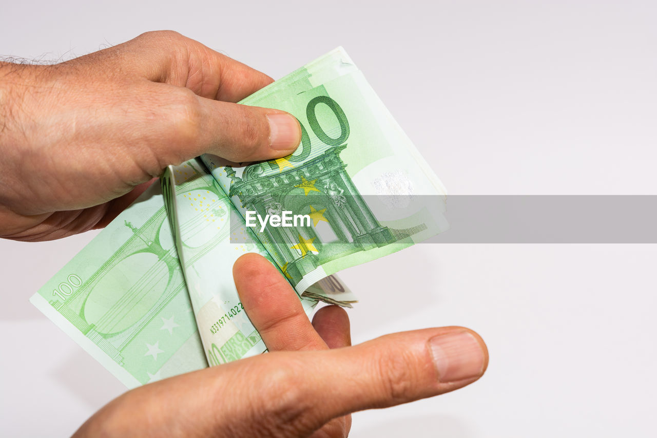 Man holding currency against white background