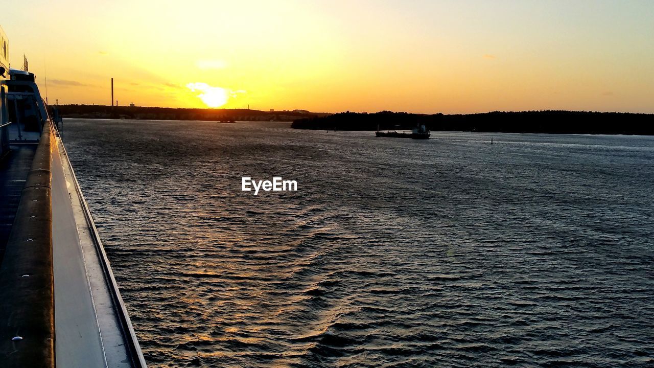 Ship in sea at sunset