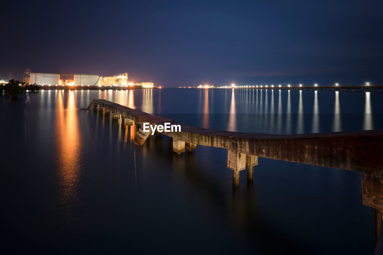 Bridge over river against sky at night