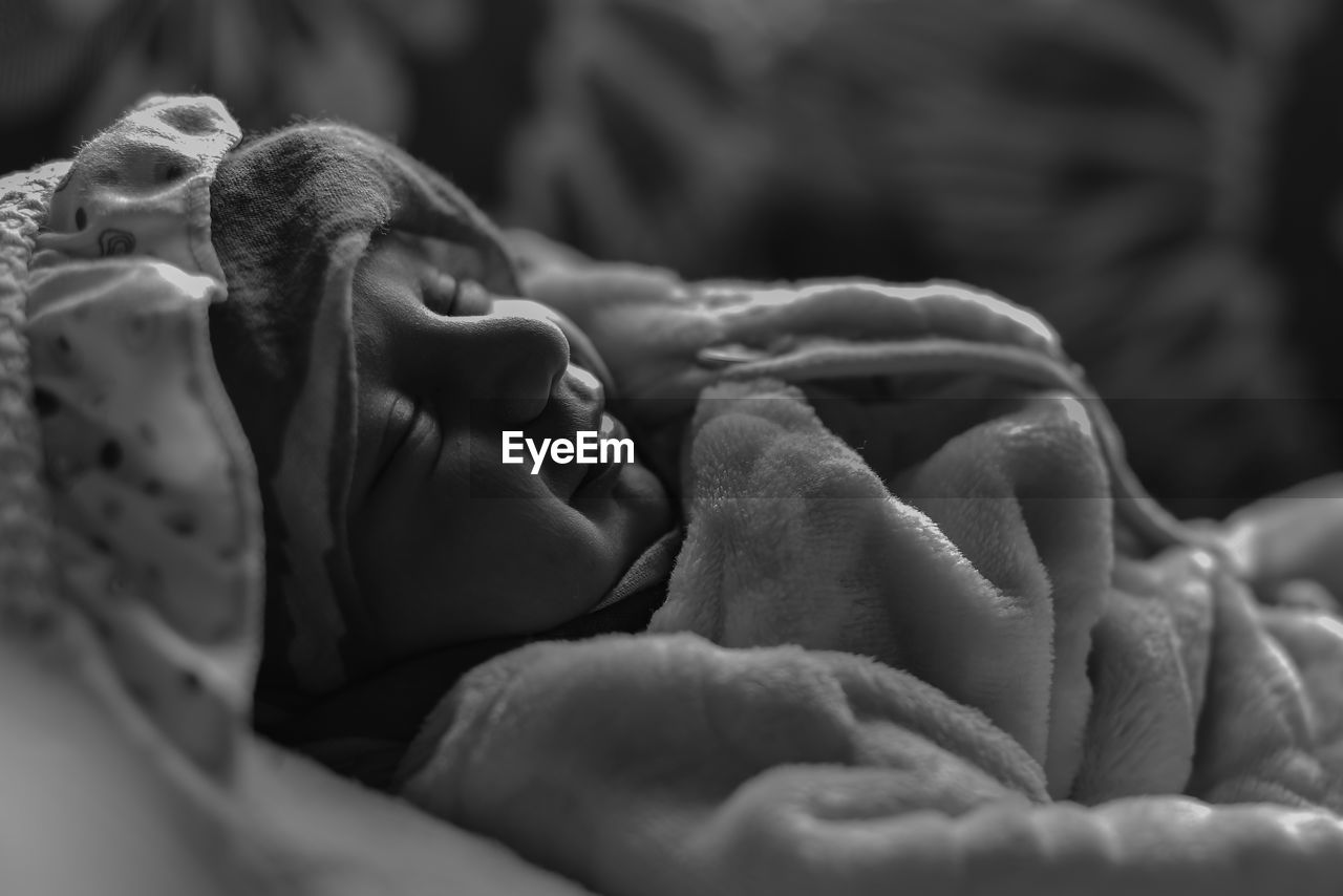 Close-up of baby sleeping on bed