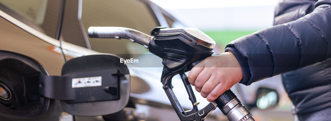 cropped hand of man holding steering wheel