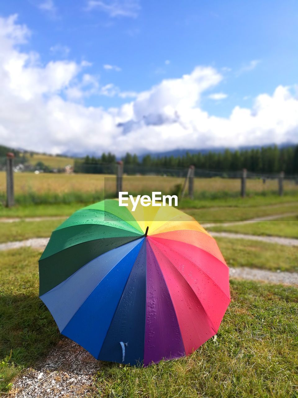 Multi colored umbrella on field against sky in cortina d'ampezzo