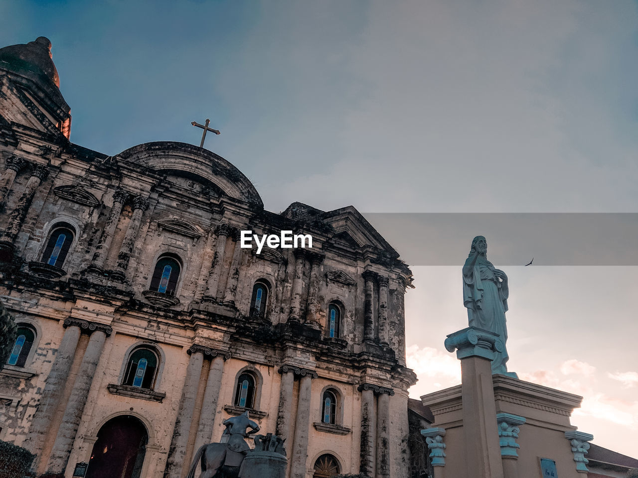 Low angle view of statue of historic building against sky