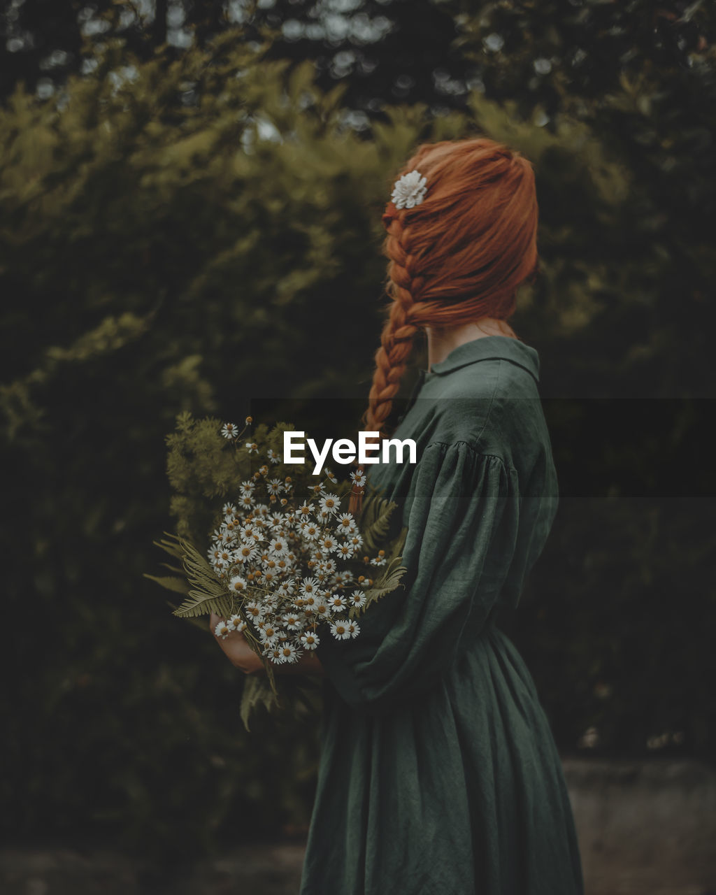 Side view of woman with wild flowers bouquet