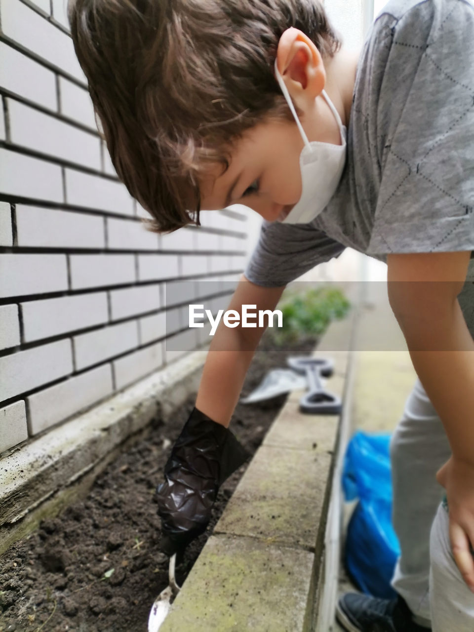 Small boy gardening during virus pandemic.