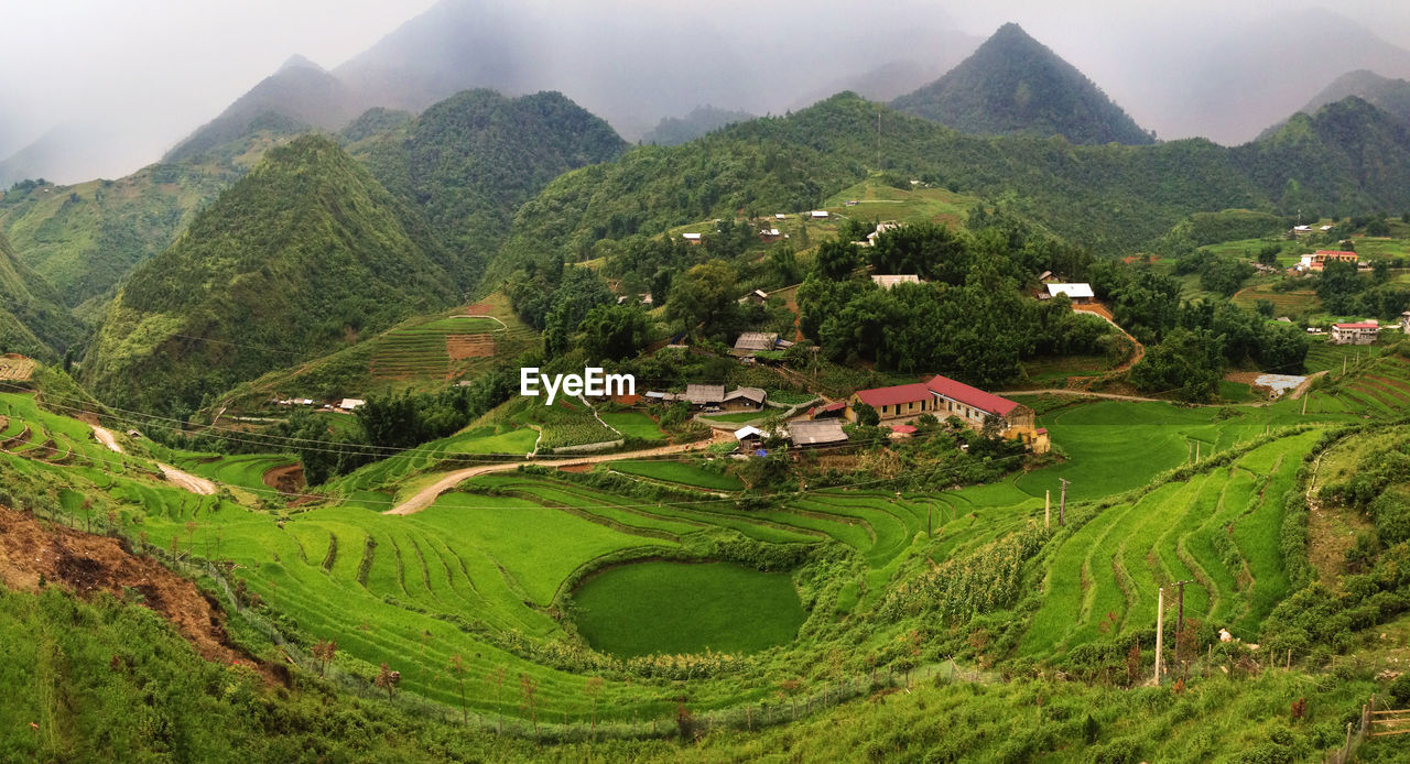 High angle view of green landscape against sky