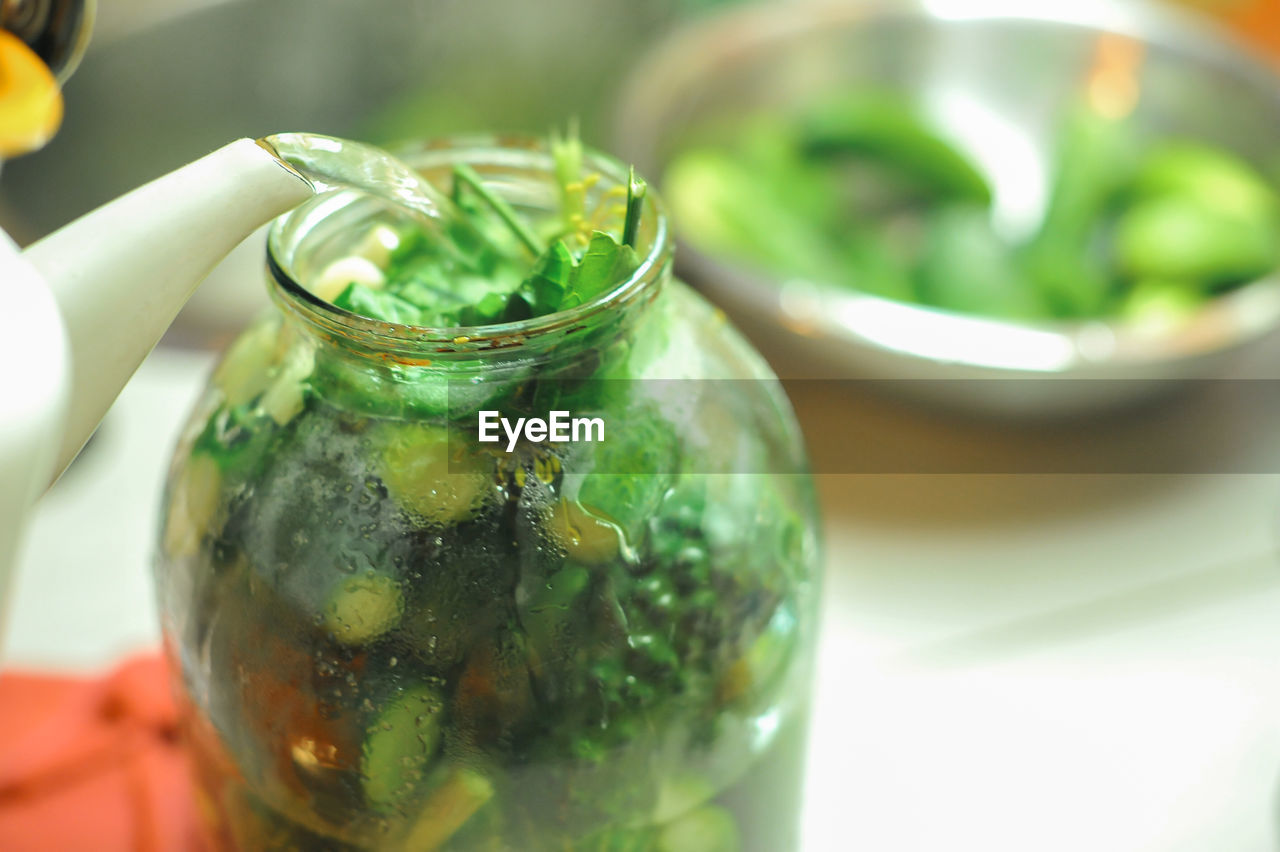 High angle view of water pouring in jar on table