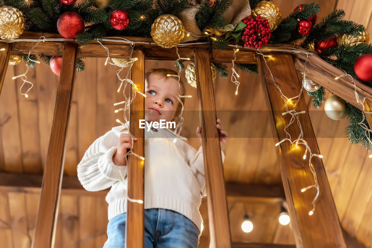 Full length of girl holding christmas decoration