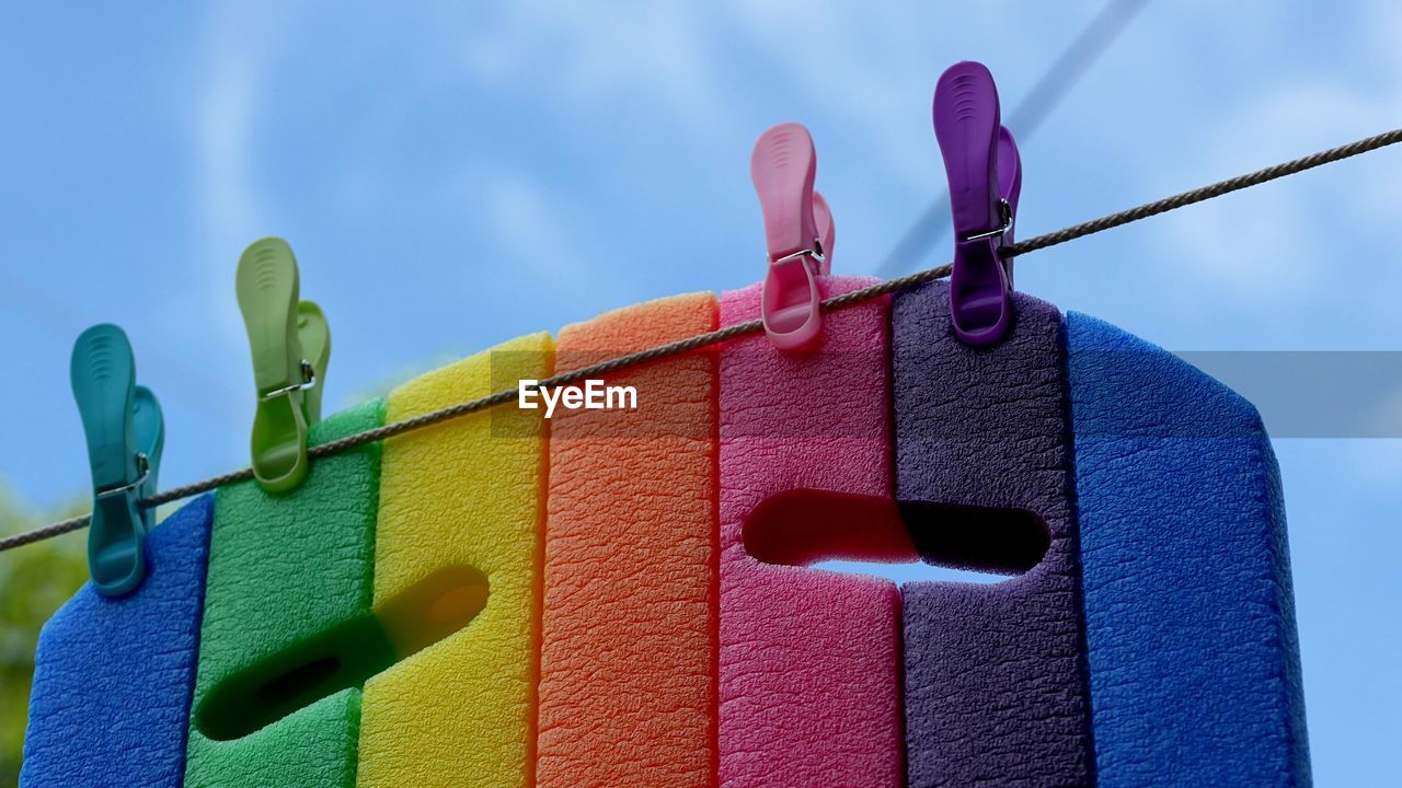 Low angle view of clothespins hanging against wall