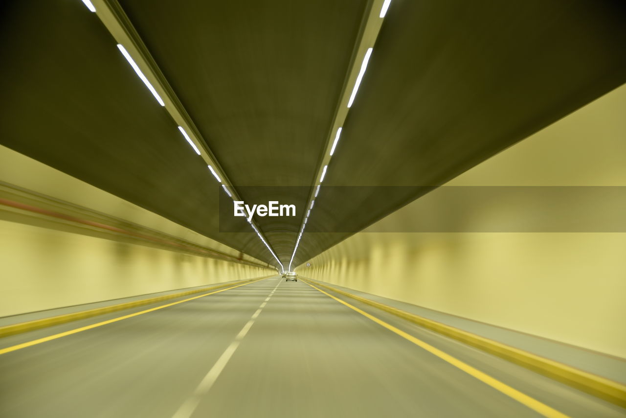 EMPTY ROAD WITH ILLUMINATED LIGHTS IN TUNNEL