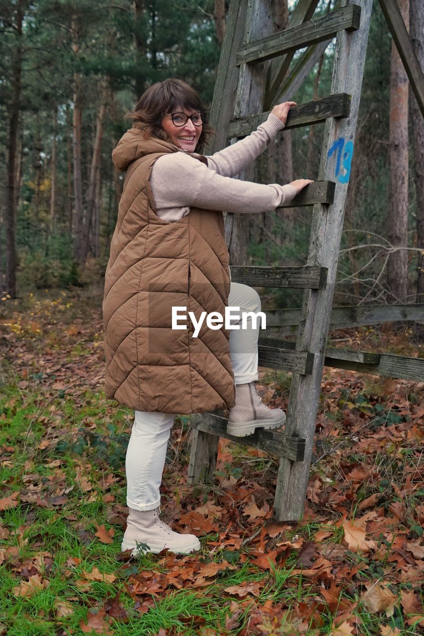 Full length of young woman standing in forest