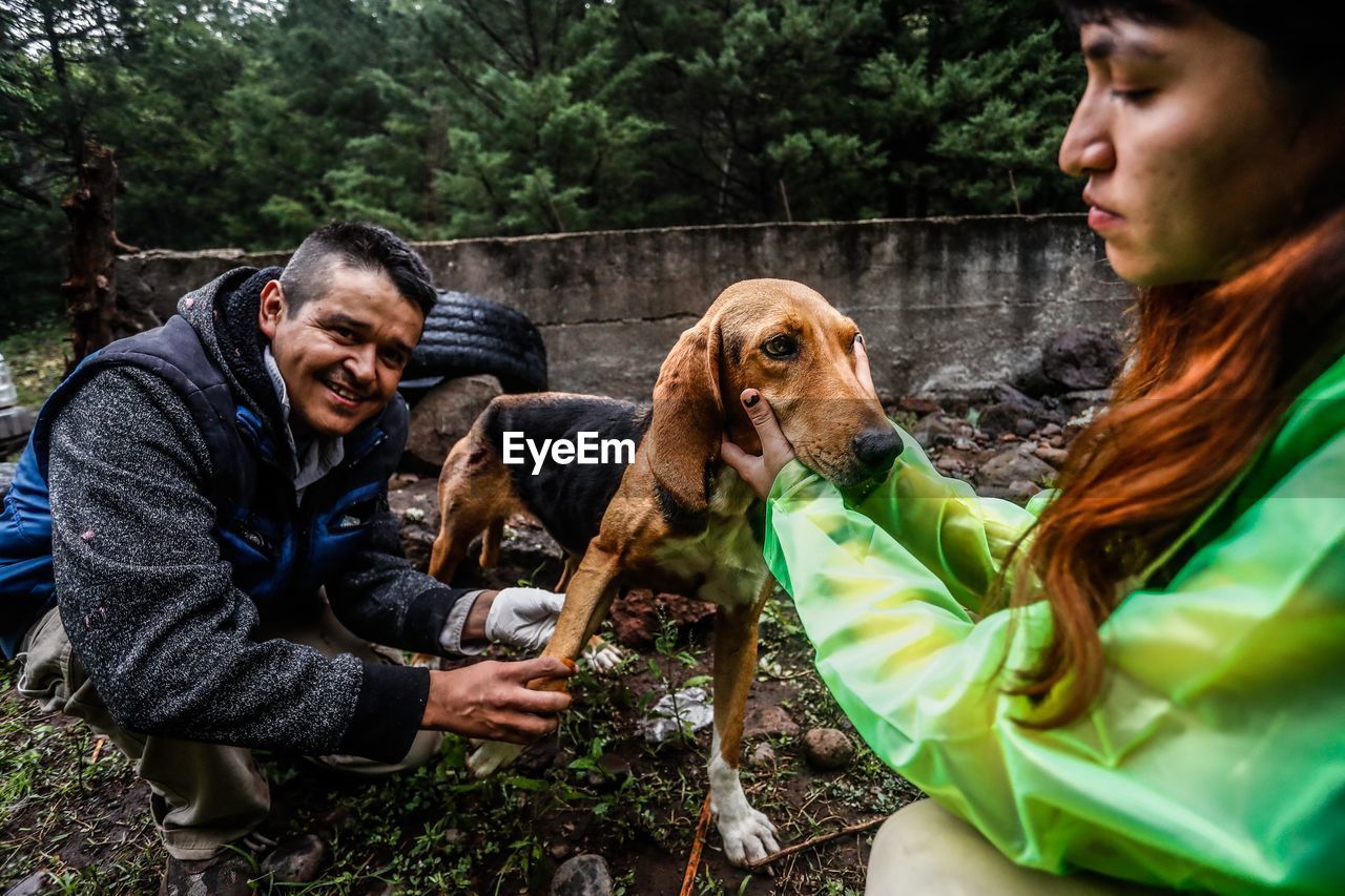 MAN AND DOG WITH PEOPLE IN FOREGROUND