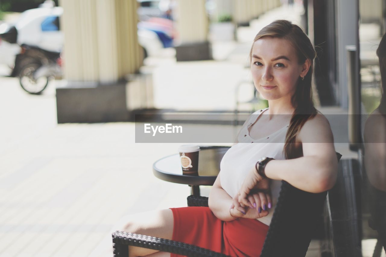 Portrait of young woman sitting on chair outdoors