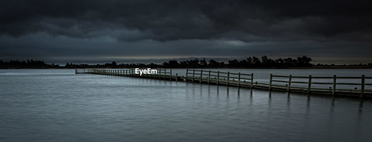 Panoramic view of pier on lake against cloudy sky at dusk