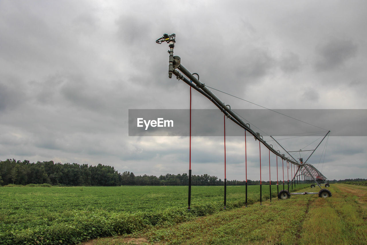 View of farm against cloudy sky