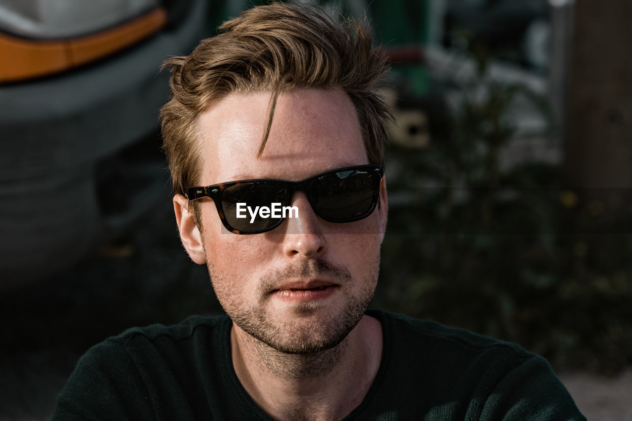 CLOSE-UP PORTRAIT OF MAN WEARING SUNGLASSES