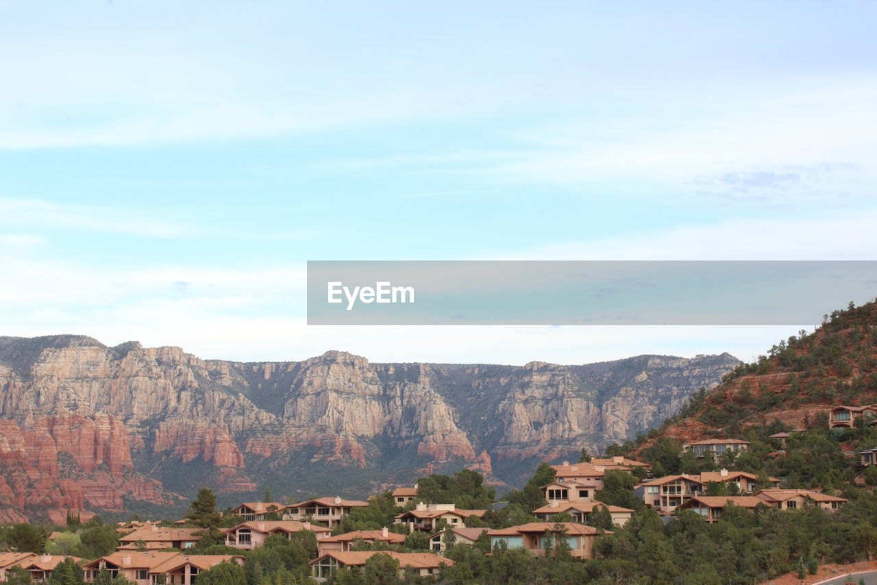 Townscape by mountain against sky