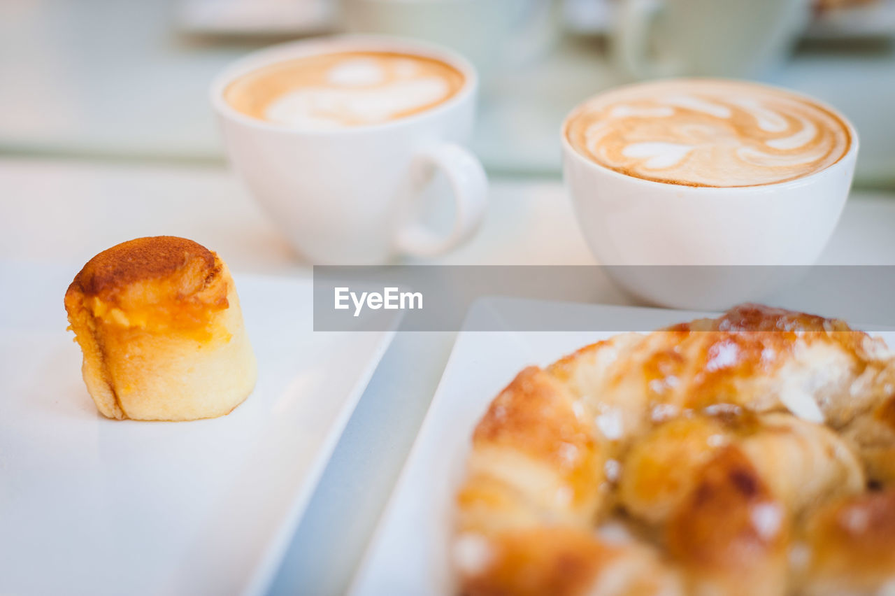 High angle view of dessert with cappuccinos and croissant served on table