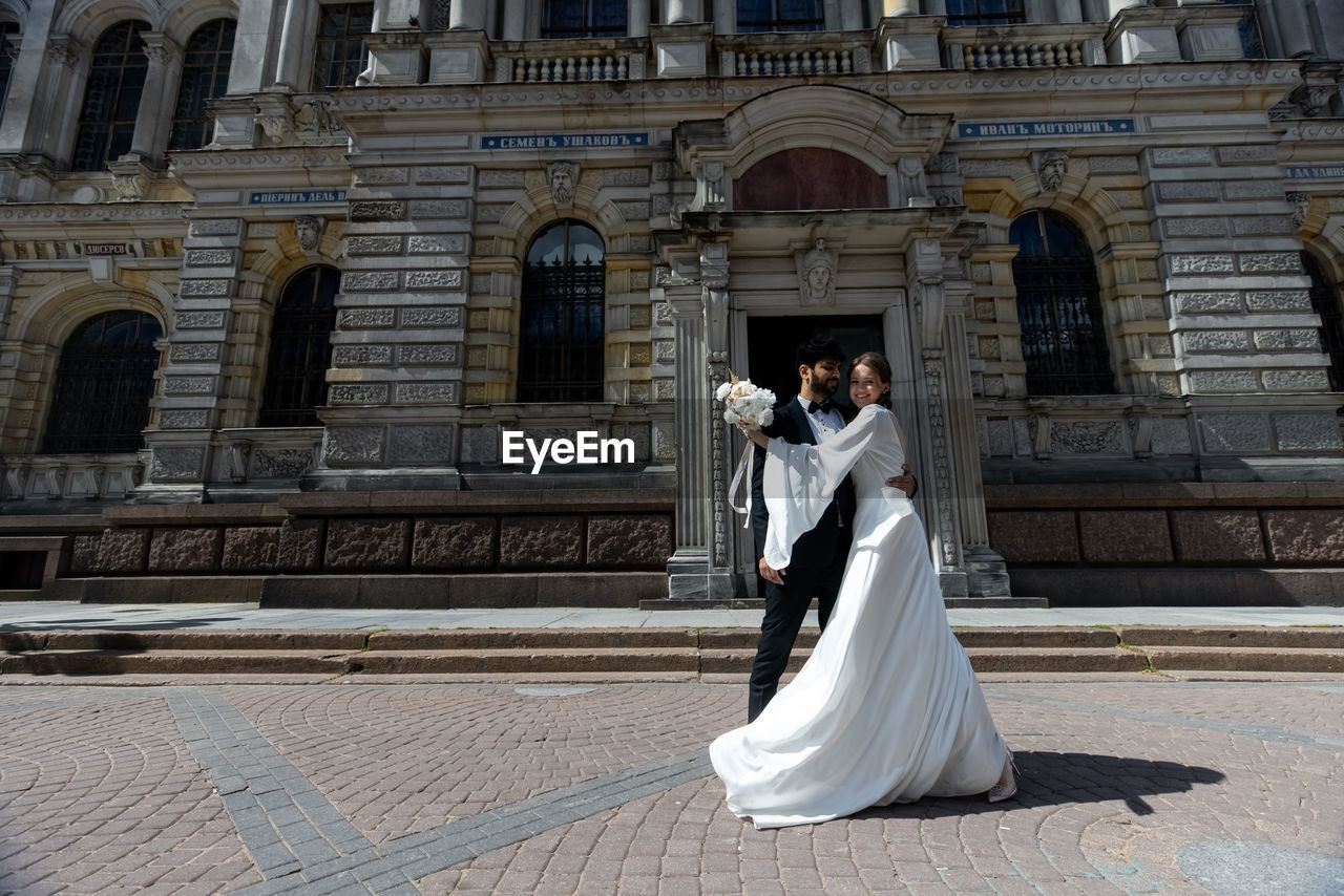 rear view of woman standing in front of historic building