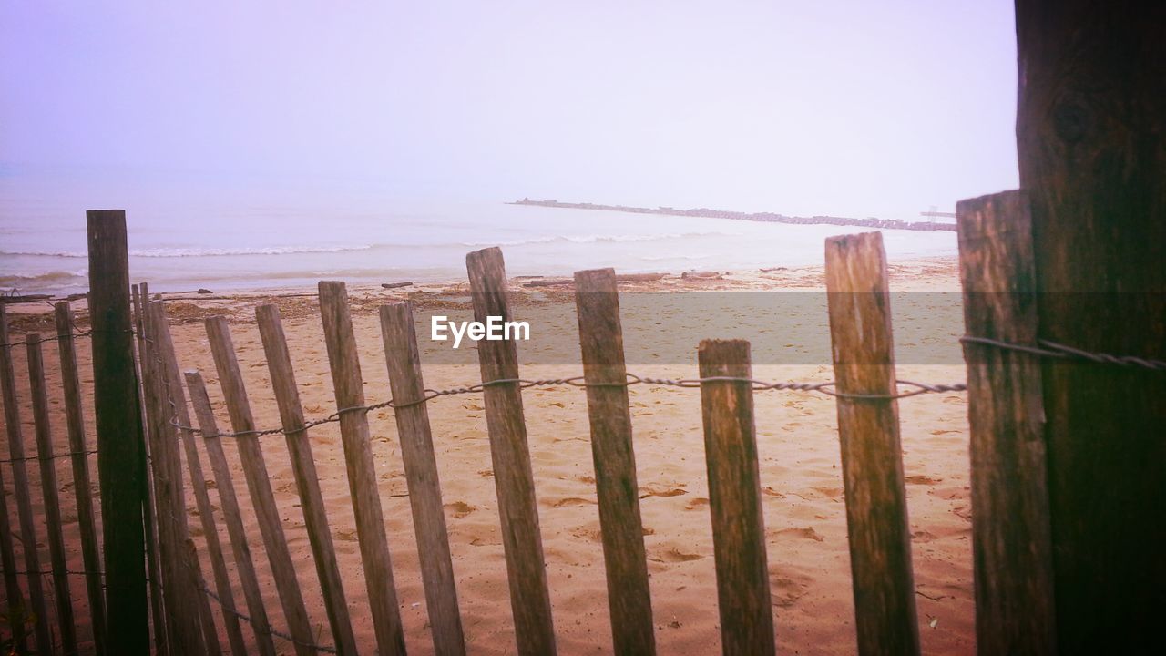 WOODEN POSTS ON BEACH