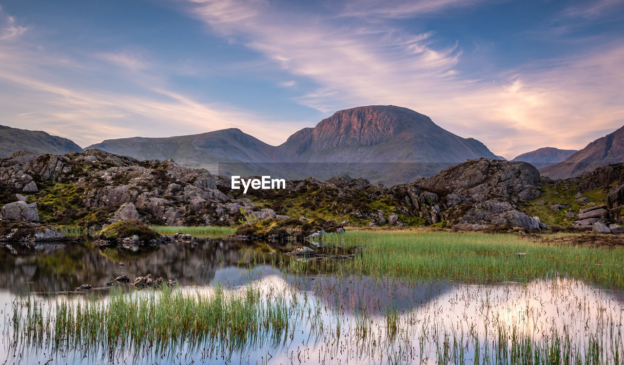 SCENIC VIEW OF LAKE BY MOUNTAIN AGAINST SKY