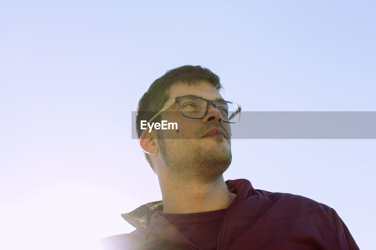 Low angle view of young man against sky