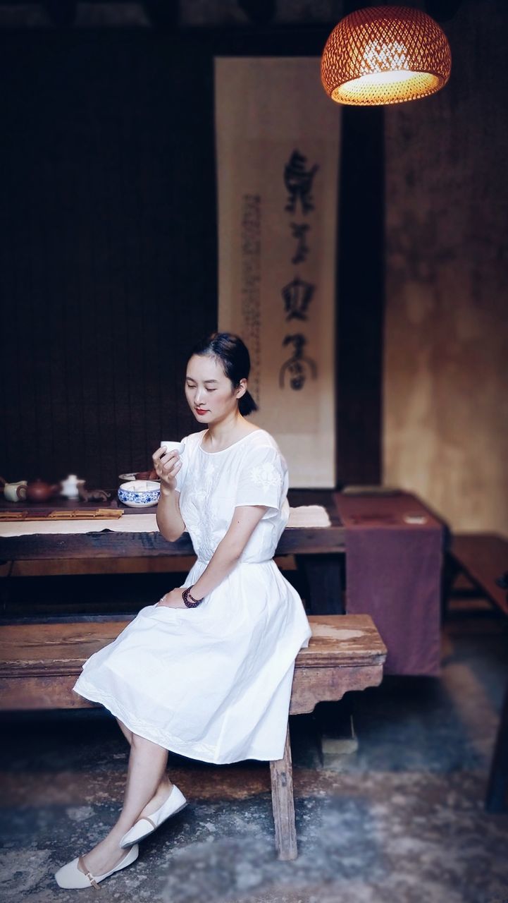 YOUNG WOMAN SITTING IN FRONT OF A SMILING