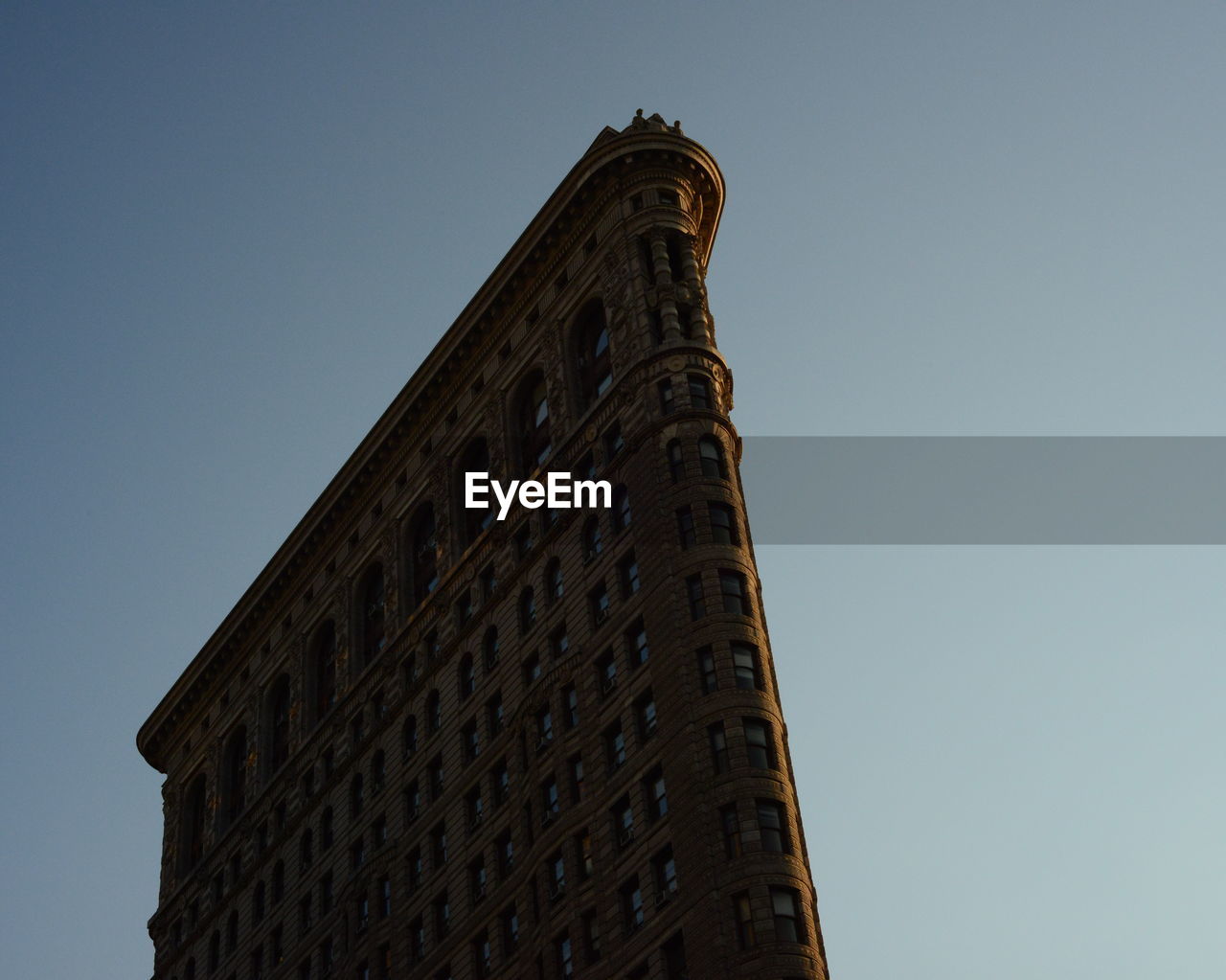 Low angle view of flatiron building against clear sky at manhattan in city