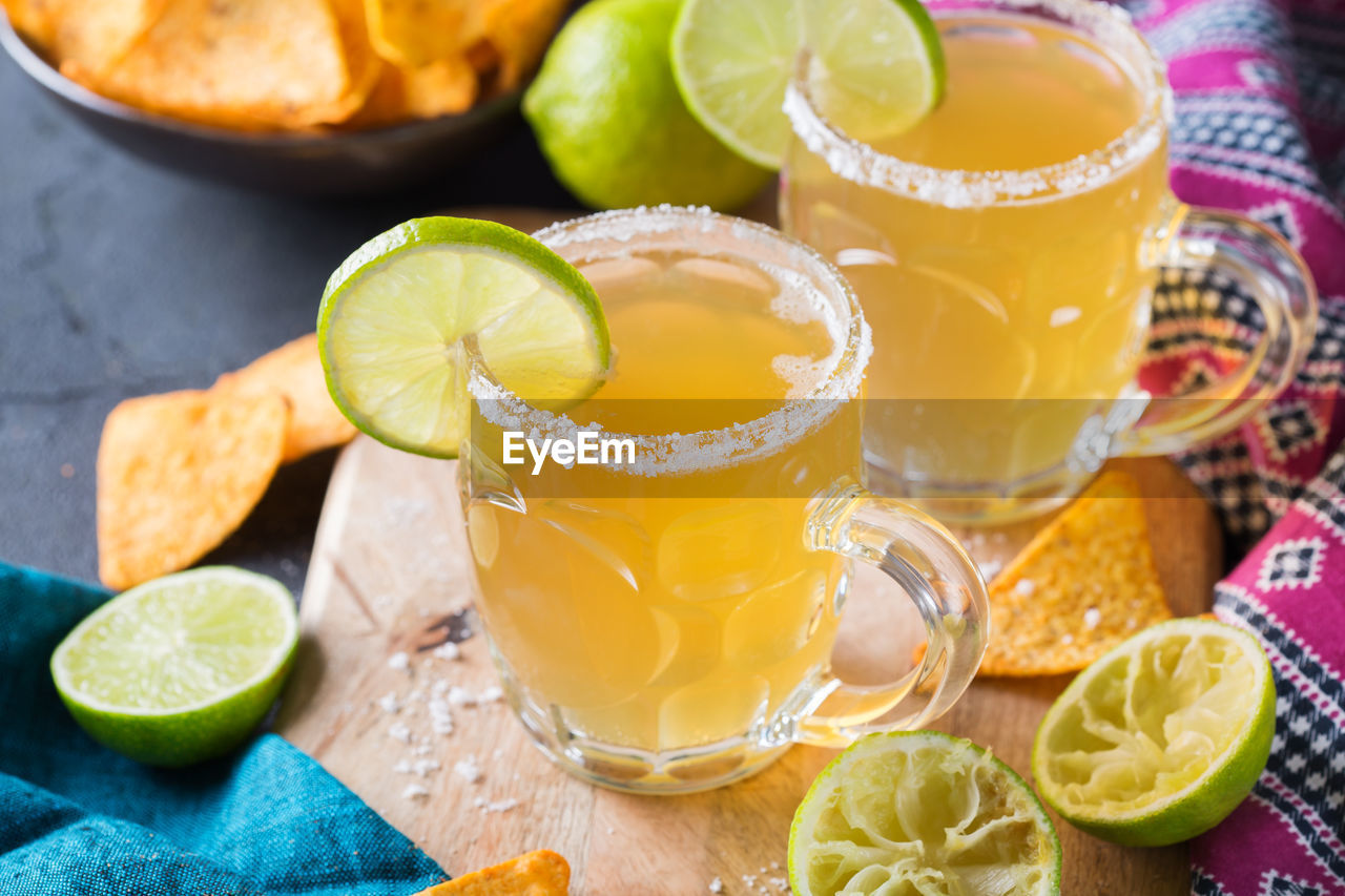 CLOSE-UP OF BEER WITH LEMON AND JUICE