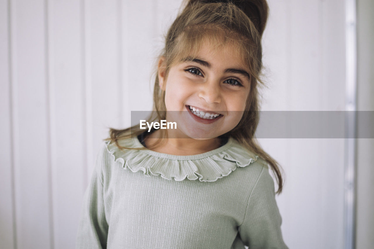 Portrait of happy girl in classroom at kindergarten