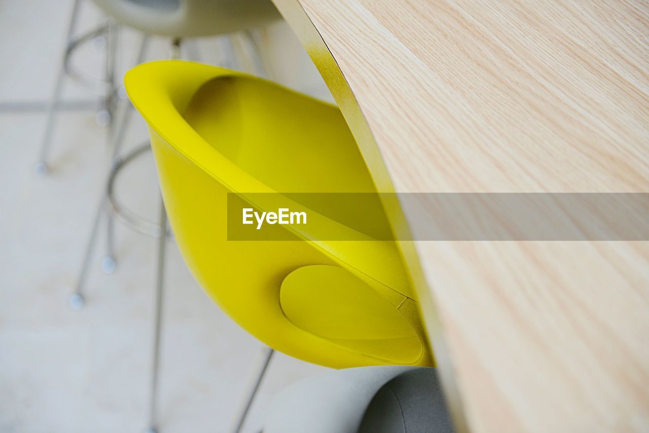 Close-up of yellow chair by table