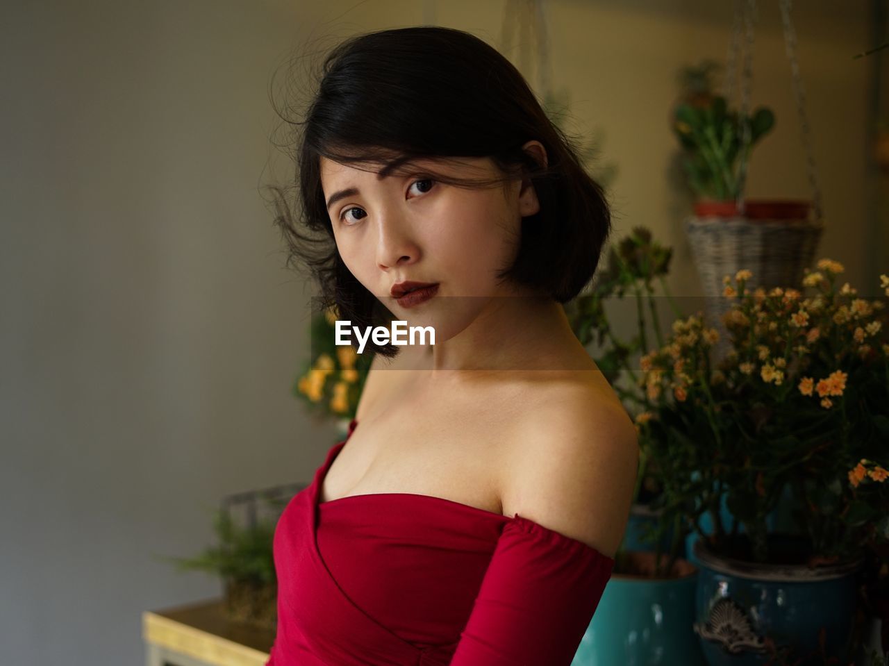 Portrait of beautiful woman against potted plants