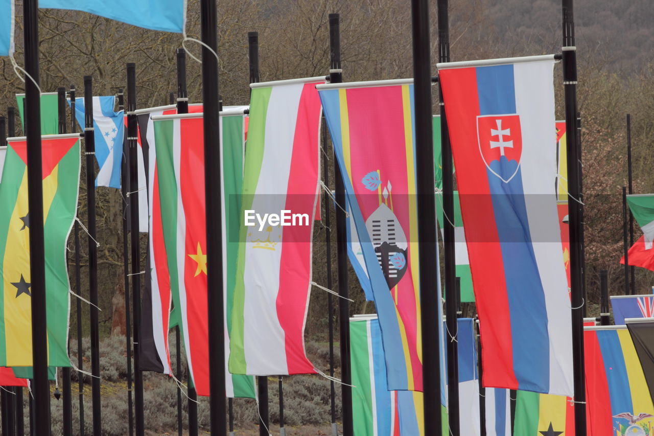 CLOSE-UP OF COLORFUL FLAGS HANGING ON WALL