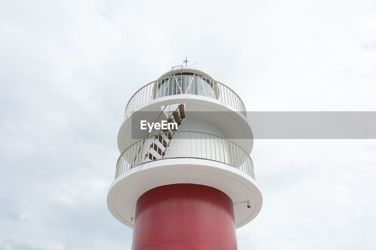 Low angle view of lighthouse against cloudy sky