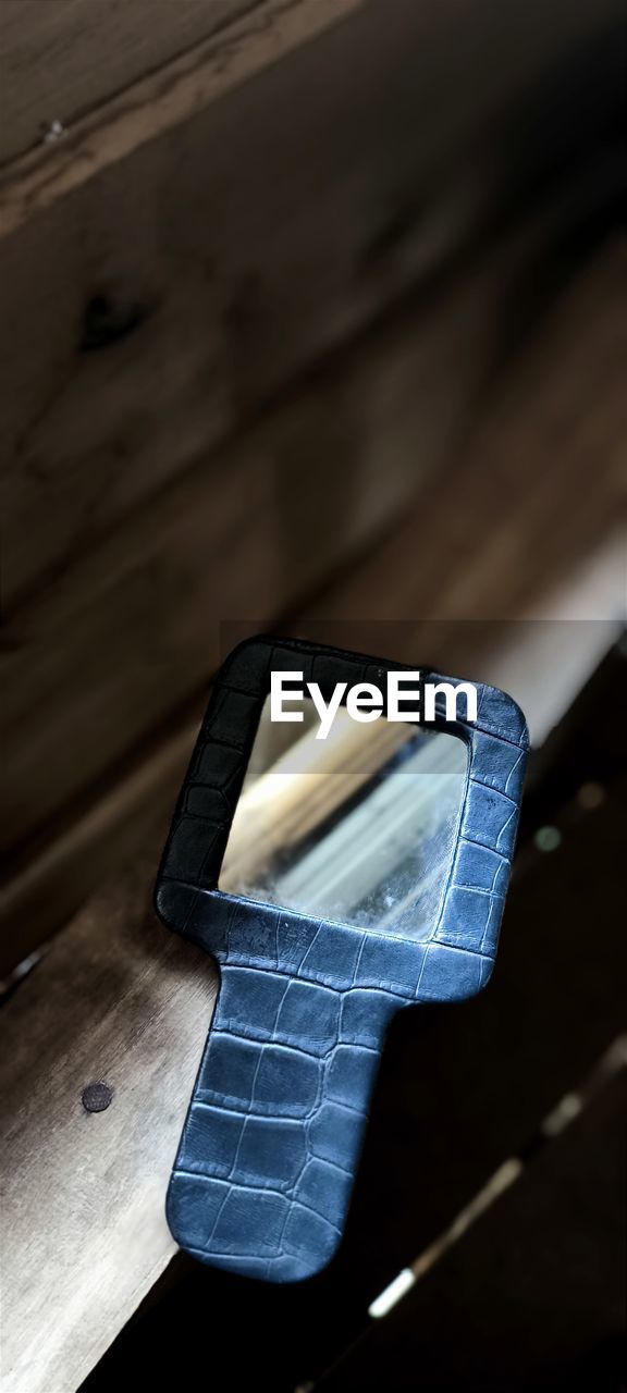 technology, black, light, wireless technology, blue, communication, portable information device, smartphone, white, mobile phone, wood, hand, close-up, indoors, high angle view, focus on foreground