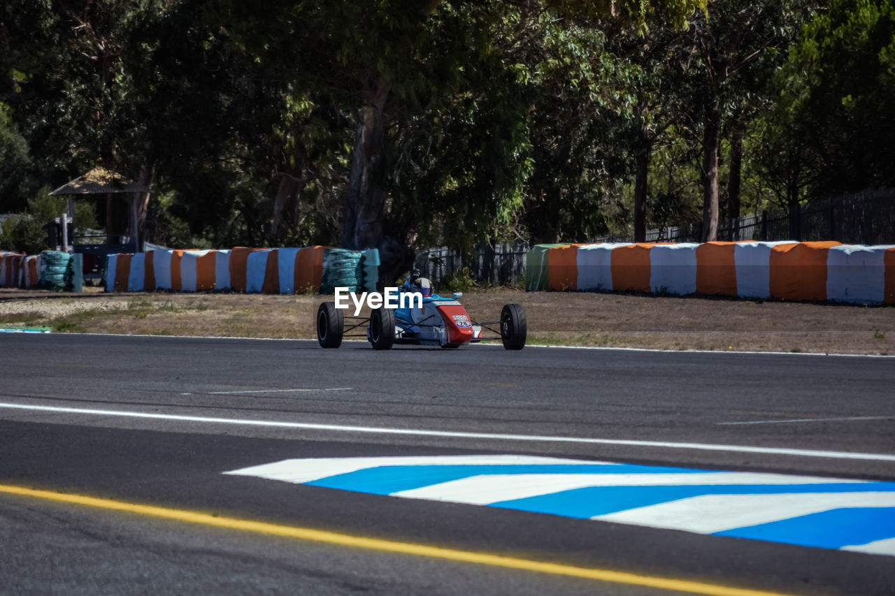 Racecar on track against trees