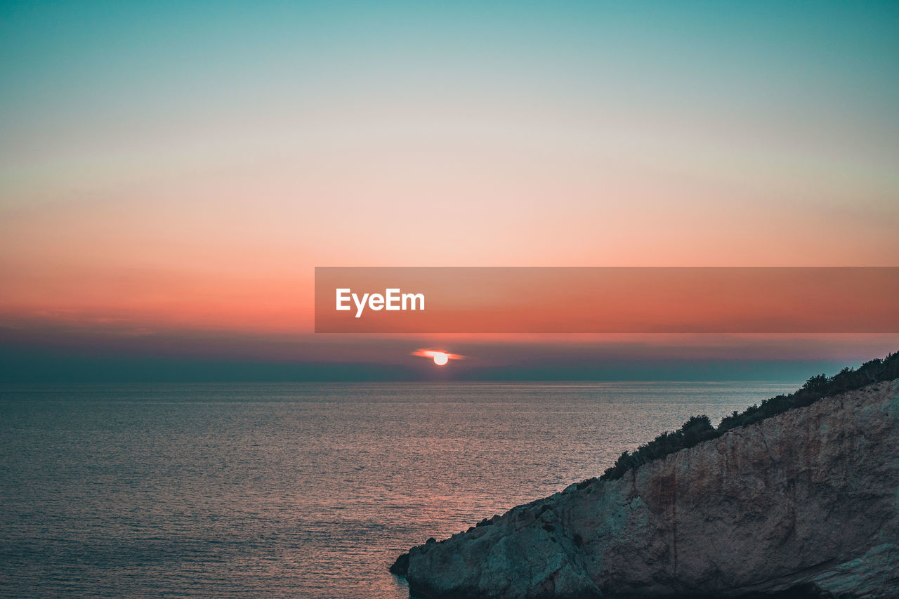 scenic view of sea against clear sky during sunset