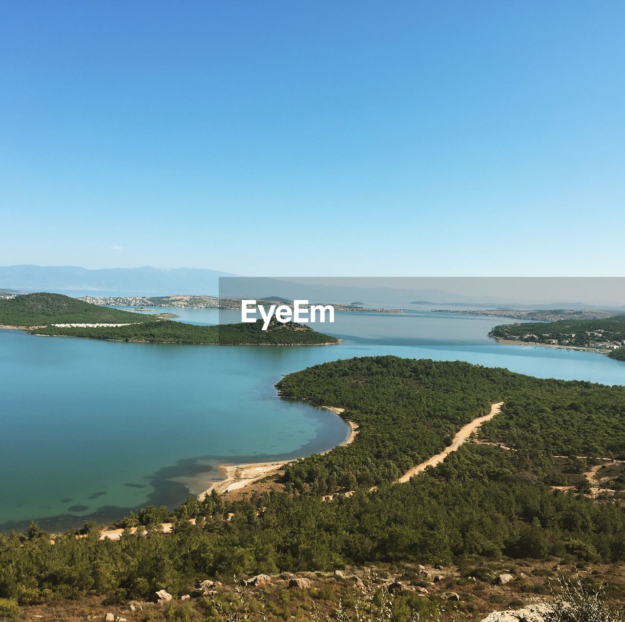 Scenic view of lake against clear blue sky