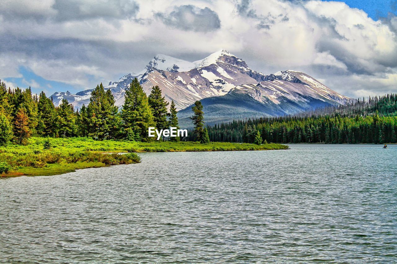 Scenic view of lake by mountains against sky