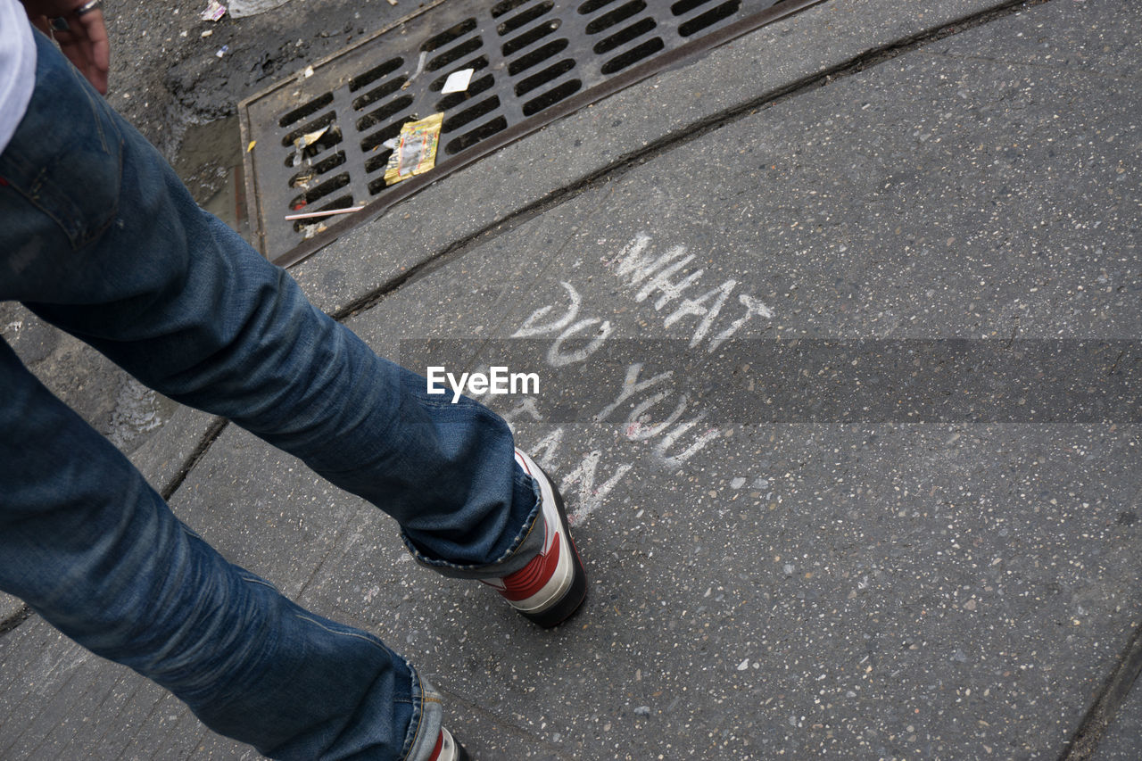 CROPPED IMAGE OF PERSON STANDING ON ROAD