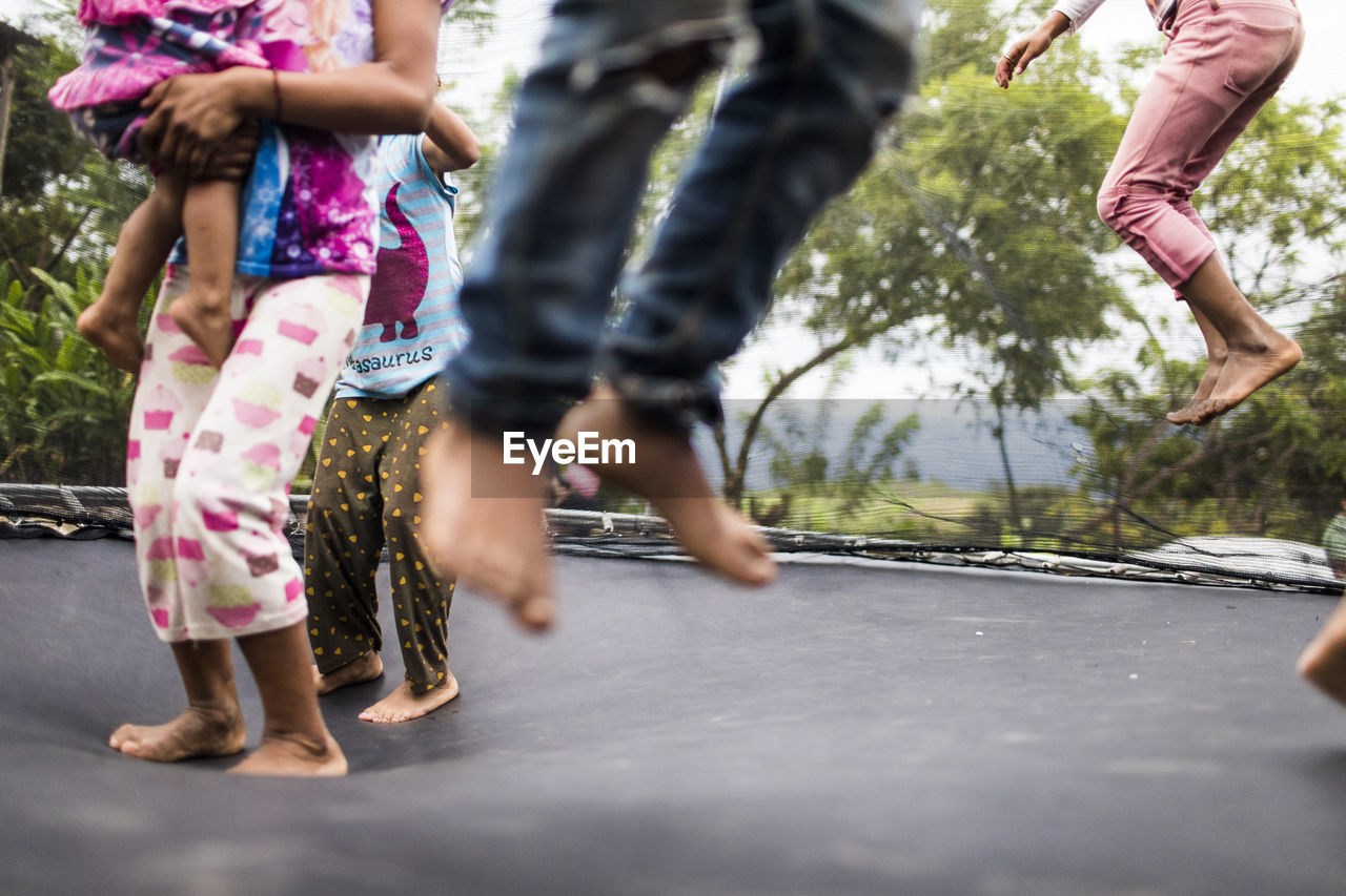 Kids jumping on backyard trampoline.