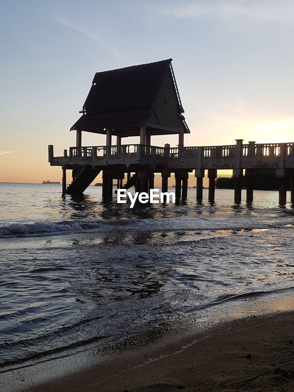 BUILT STRUCTURE ON BEACH AGAINST SKY DURING SUNSET