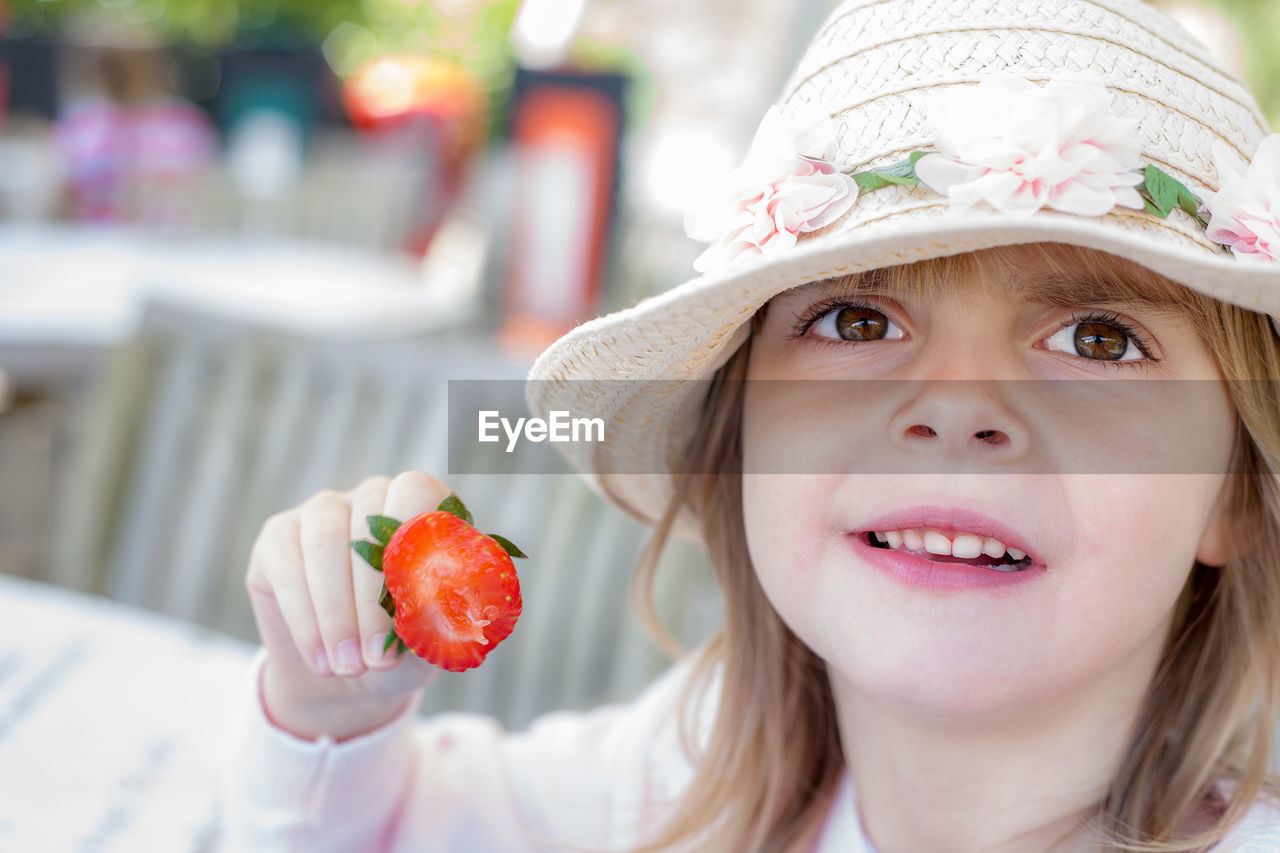 Close-up of girl holding strawberry