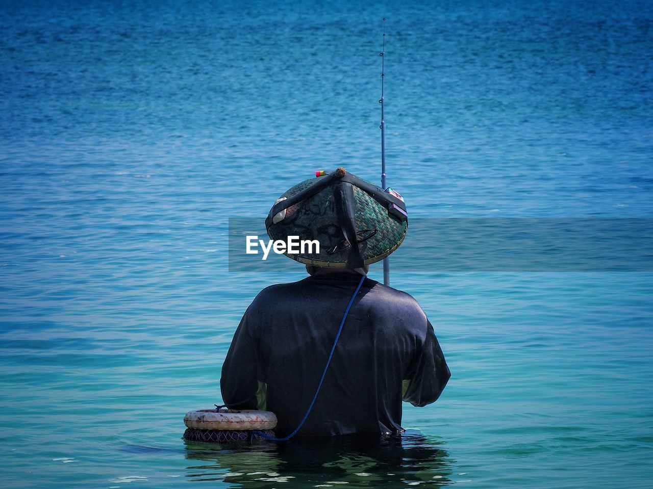 Rear view of man fishing in lake