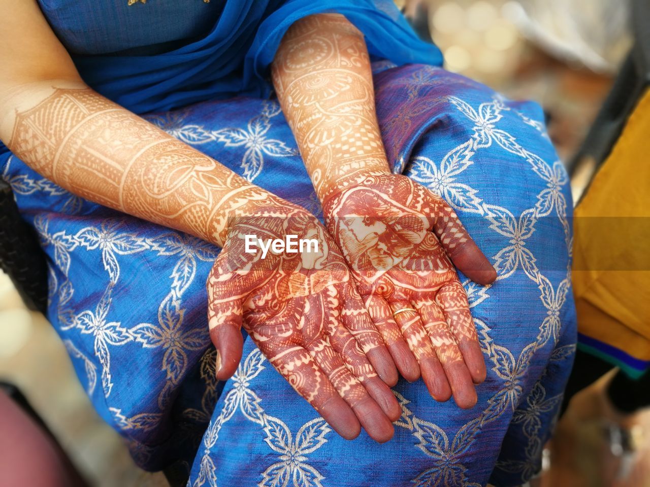 Midsection of woman with henna tattoo on hand